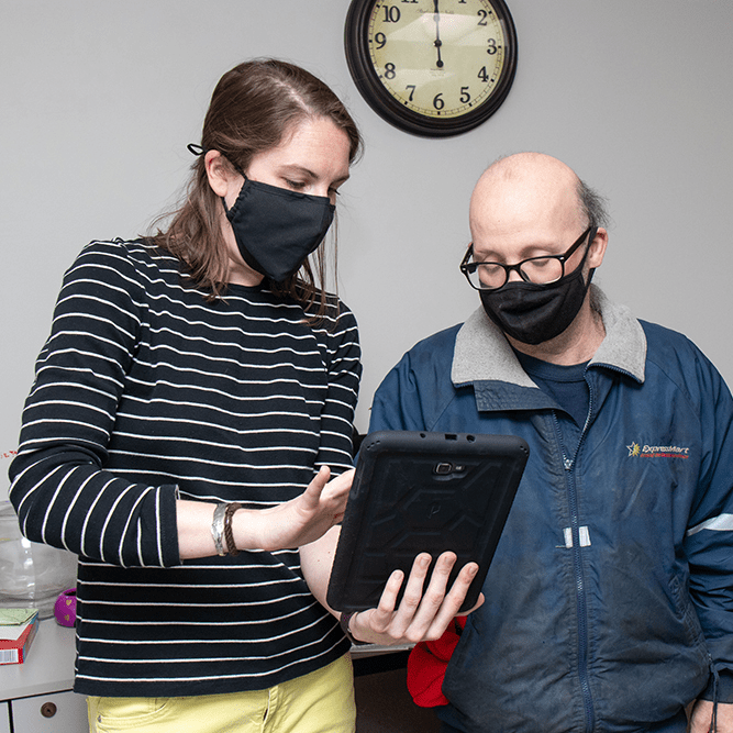 Assistant Director Carey Peters shows STC member Richard Elmer consent forms on an electronic tablet device.