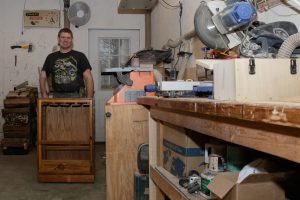 Mike in the workshop showing off some of the things that he has made.