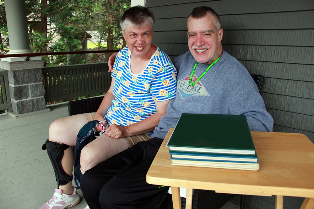 Janet and Chris Vance sitting on the porch of Chris' residence at Cook Street Community Home