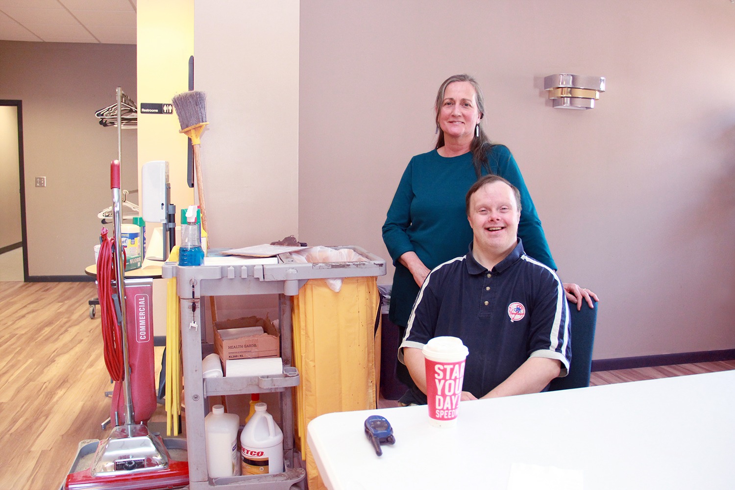 Care Coordination Manager Terri McCue poses with Jason LeBeau as he sits enjoying his extra-large decaf coffee before he starts his shift. 